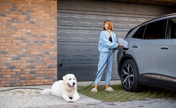 Photo d'une borne installée et d'un client qui l'utilise pour charge son véhicule électrique